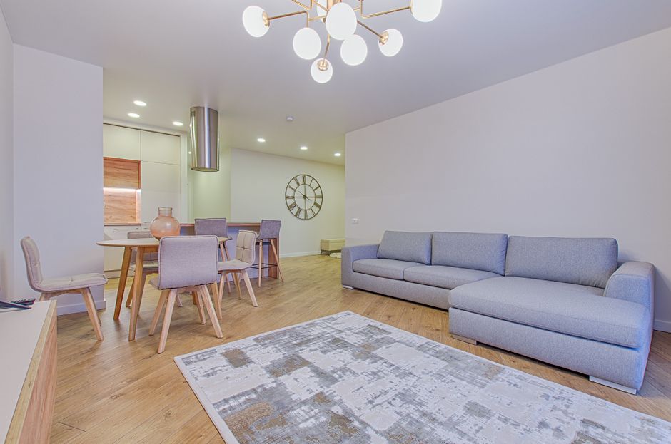 Spacious contemporary living room featuring stylish furniture and elegant lighting.