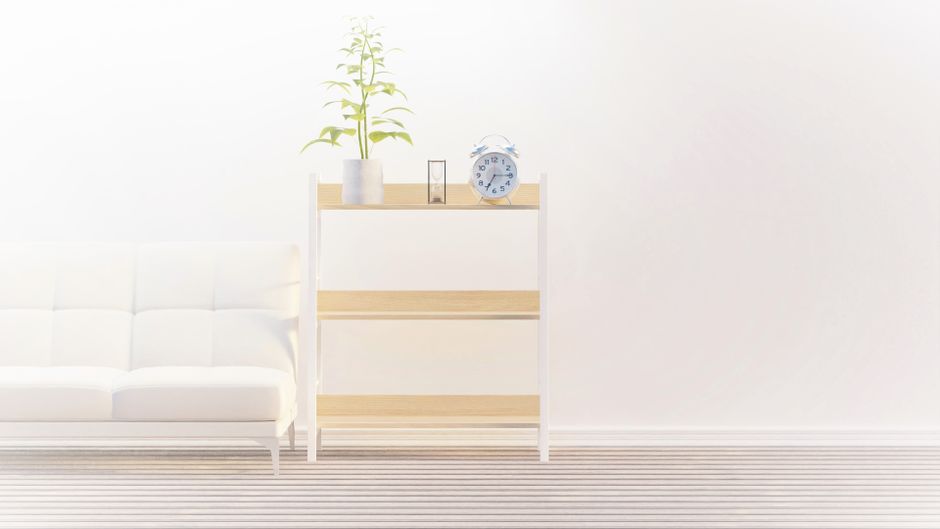 Bright, modern interior with white couch, wooden shelves, and a clock.